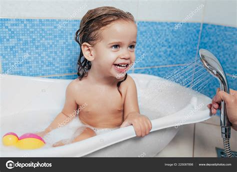 Beautiful Little Girl Taking A Bath At Home A Cute Baby Is Sitting In