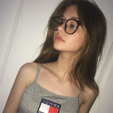 A Woman Wearing Glasses With A Tommy Flag Patch On The Side Of Her Tank Top