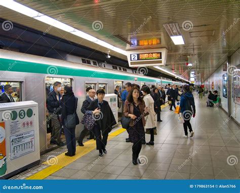 commuters leave a crowded train on the busy subway underground at a station in kyoto japan