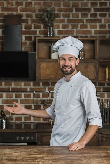 Retrato De Chef Hombre Parado En La Cocina Presentando Foto Gratis