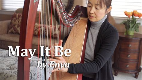 A Woman Playing A Harp With The Words May It Be By Enya In Front Of Her