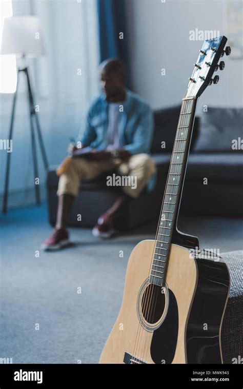 Close Up View Acoustic Guitar Standing In Room And African American