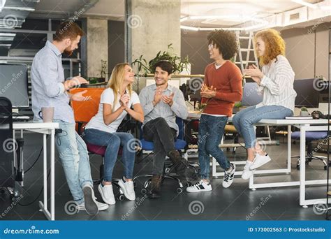 Cheerful Young Coworkers Welcoming New Colleague In Modern Coworking