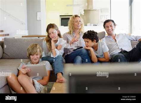 Familia viendo la televisión juntos en casa Fotografía de stock Alamy