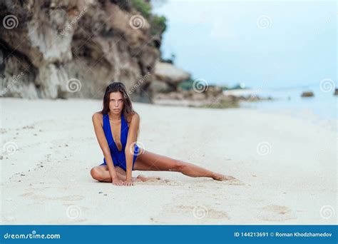 Tanned Model In Blue Swimwear Posing On White Sandy Beach Stock Image