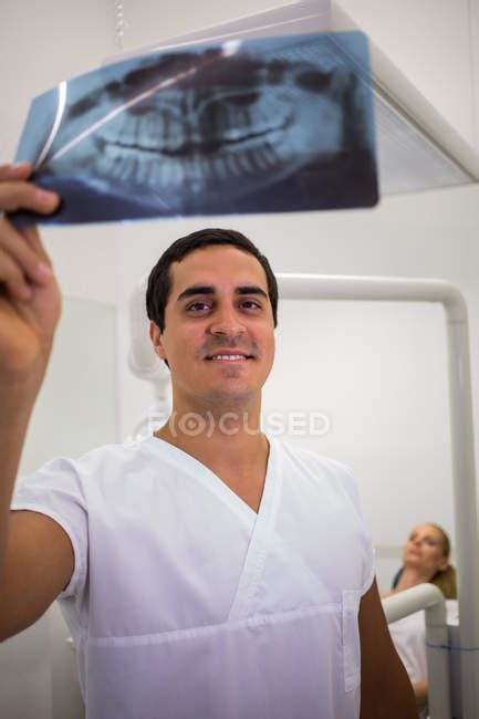 Dentist Looking At Dental X Ray Plate In Clinic — Radiologist Patient