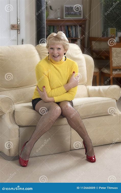 Woman Sitting On A Sofa Wearing Fishnet Tights Stock Image Image Of