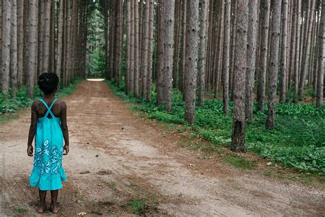 african american girl in blue dress on a road in the forest by stocksy contributor gabi