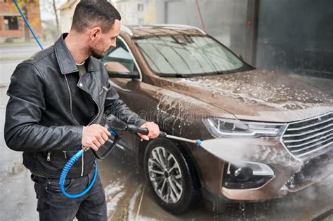 Man Cleaning Car By Water From High Pressure Water Gun Stock Photo