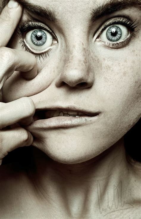 A Woman With Freckles On Her Face And Eyes Looking At The Camera While