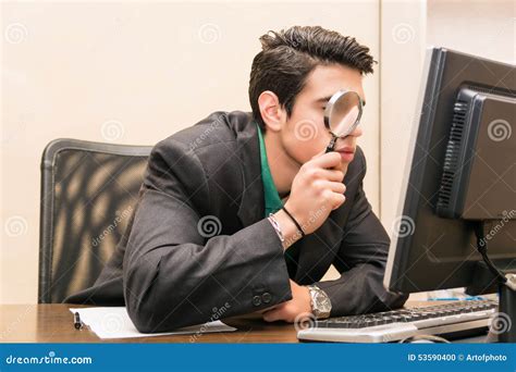Businessman Searching Through Magnifying Glass In Stock Photo Image