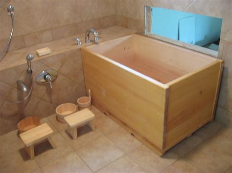 This rustic style bathroom has a japanese soaking tub in front of a large bay window. MachWerx » Blog Archive » Ofuro!
