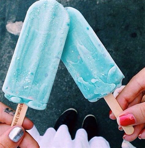 Two People Holding Popsicles With Blue Icing And Pink Nail Polishes On Them