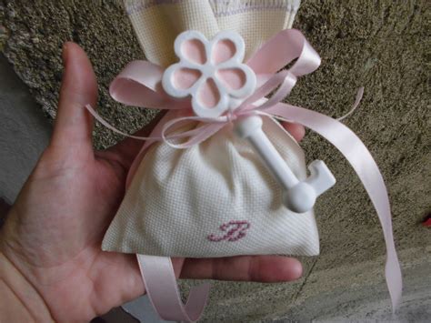 Bomboniera per il battesimo della tua bambina raffigurante una bimba dentro un pacco regalo di colore rosa + 3 confetti al cioccolato. Bomboniere Ricamate di Sara: bomboniera battesimo bimba