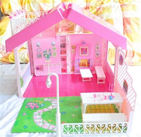 A Pink Doll House With Furniture And Accessories On The Floor In Front