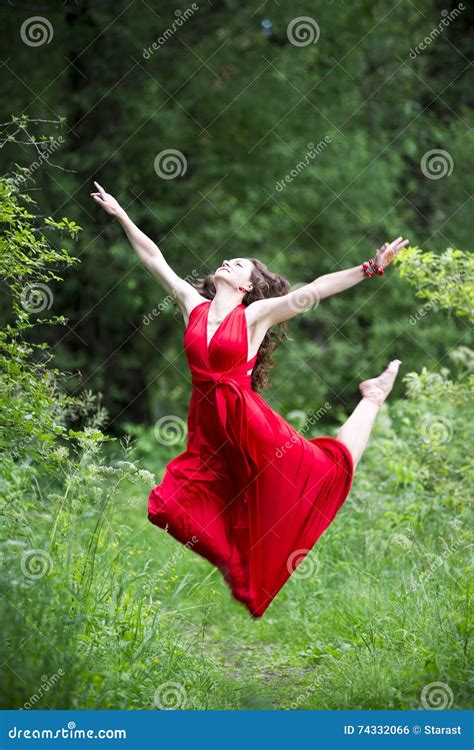 Happy Beautiful Young Caucasian Brunette Woman In Red Dress Jumping