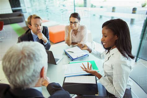 Business People Talking At Table In Office Building Stock Photo