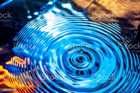 Water Drop Ripple Over A Colorful Water Surface Stock Photo Download