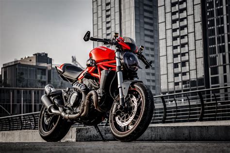 Red And Black Motorcycle Parked Beside Gray Concrete Building · Free