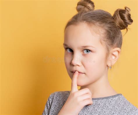 Pensive Little Girl Presses Her Finger To Her Chin Imagining The Idea