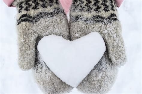 Premium Photo Womens Hands In Woolen Mittens Hold A Snowy Heart