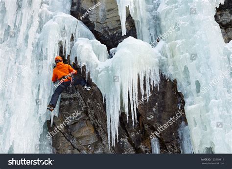Ice Climber On His Way Up On A Frozen Waterfall In South