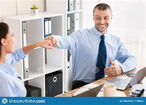 Cheerful Business Coworkers Bumping Fists Celebrating Success Sitting In Office Stock Image