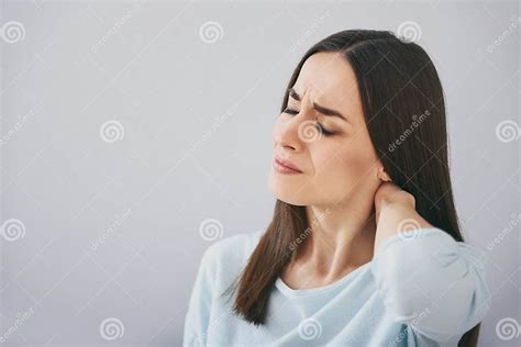 Pretty Exhausted Woman Closing Eyes And Standing Against White Wall