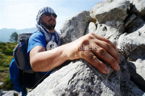 Young White Man Climbing A Steep Wall In Mountain Rock Climbing And