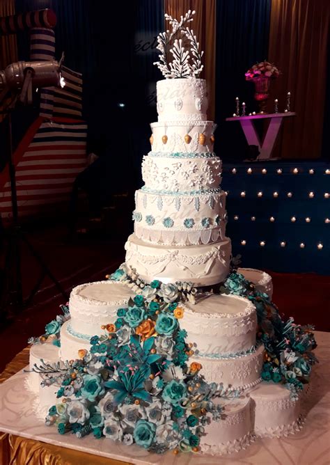 White Weddingcake With Turquoise And Gold Flowers