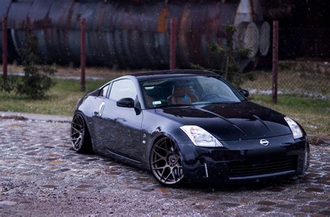 A Black Sports Car Parked In Front Of A Train