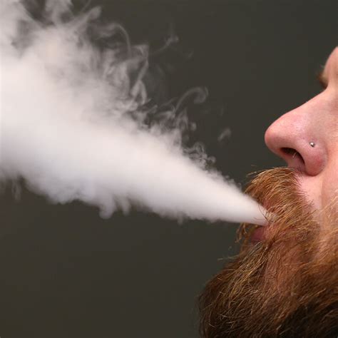 A Man With A Red Beard And Mustache Only His Mouth And Nose Showing Exhales E Cigarette Smoke