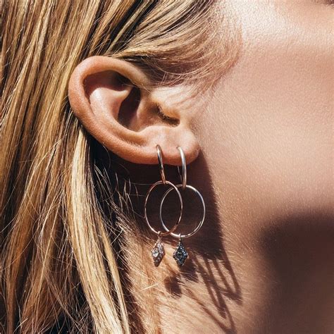 Two Hoops Hanging Together With Dangling Evil Eye Charm Hoops Hang