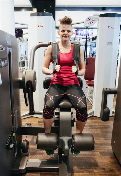 A Woman Sitting On Top Of A Machine In A Gym