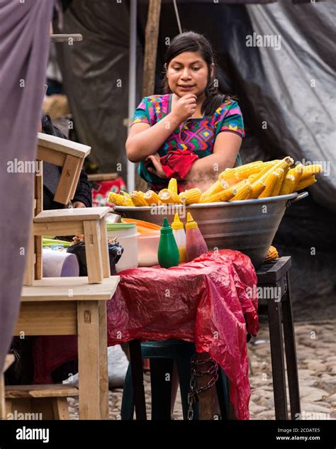 A Young Quiche Mayan Woman In Traditional Dress Sells Elote Or Steamed