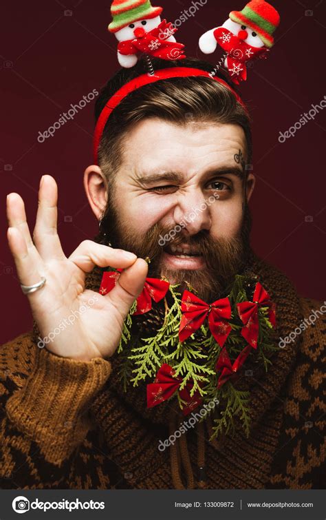 Funny Bearded Man In A New Years Image As Santa Claus With Decorations On His Beard Feast Of