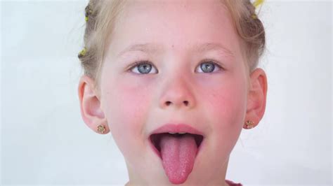 女孩张大嘴巴，伸出长长的舌头。孩子向牙医展示牙齿、软腭和口腔—高清视频下载、购买视觉中国视频素材中心
