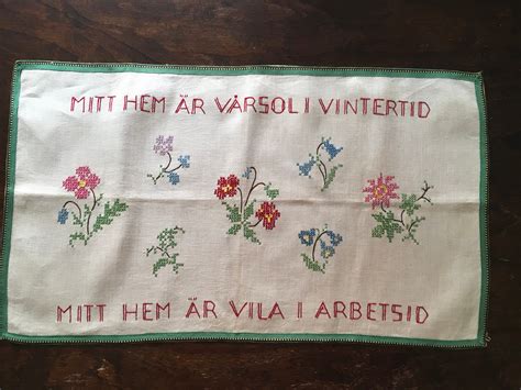 An Embroidered Cloth With Flowers And Words Written On The Front Is