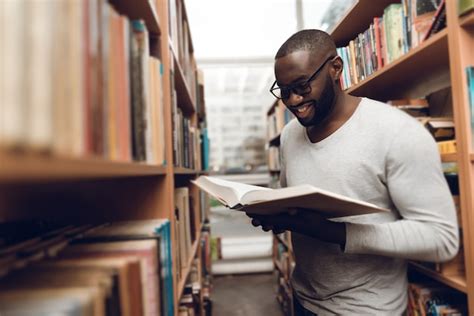 Premium Photo Ethnic African American Guy Reading Book In Library