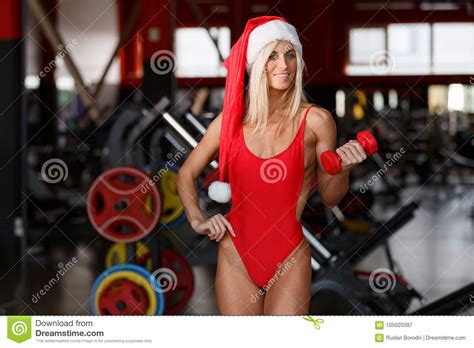 Fitness Woman Wearing A Red Bathing Suit Wearing A Santa Hat Is