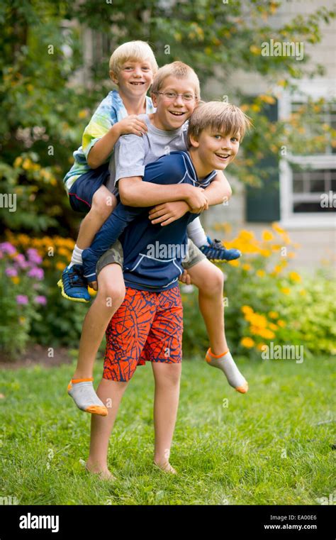 Three Boys Playing Piggyback In Garden Stock Photo Alamy