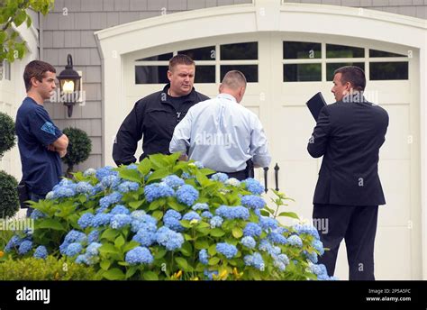 Police investigators work outside the home of former New England