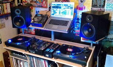 A Laptop Computer Sitting On Top Of A Desk Next To Two Decks Of Dj