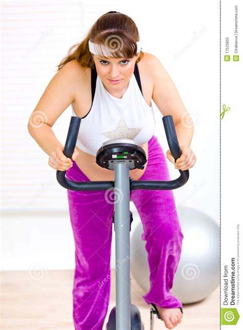 Pregnant Woman Working Out On Static Bike Royalty Free