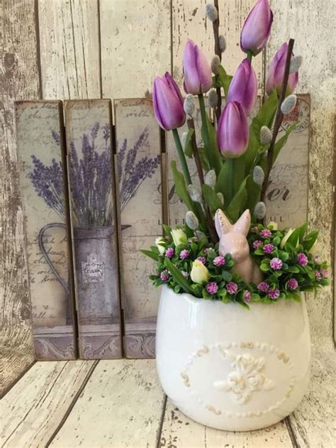A White Vase Filled With Purple Flowers On Top Of A Wooden Table