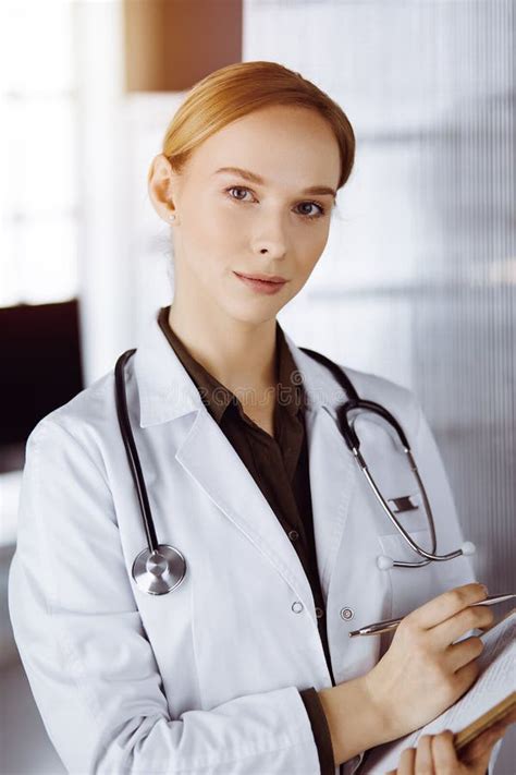 Cheerful Smiling Female Doctor Using Clipboard In Clinic Portrait Of