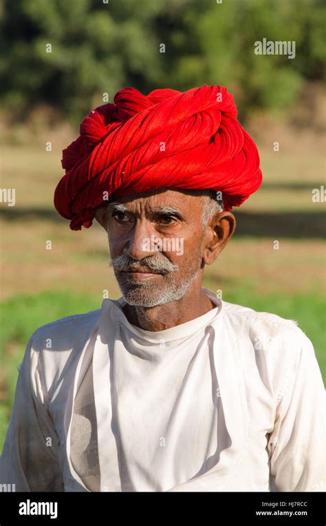 Closeup Portrait Of A Rajasthani Senior Citizen In His Farm Wearing Red