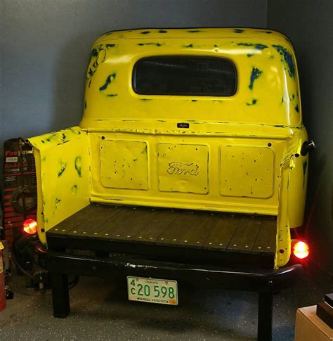 the back end of an old yellow pick up truck