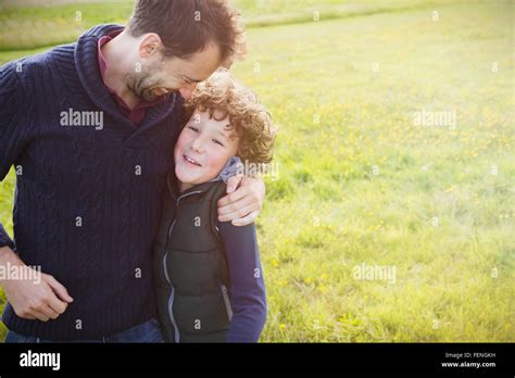 Father Hugging Son In Field Stock Photo Alamy