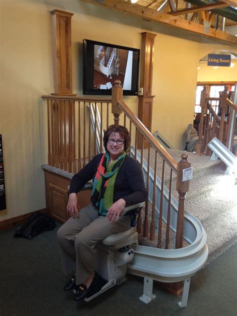 A Woman Sitting On A Chair In Front Of A Stair Case